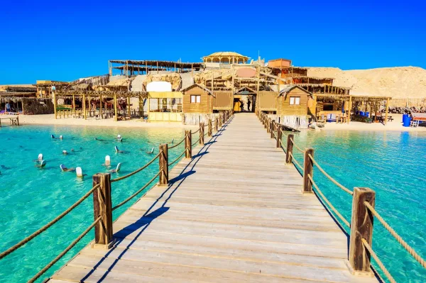 Orange Bay Hurghada - extensive white sandy beach with rustic wooden structures and turquoise waters in Eastern Egypt