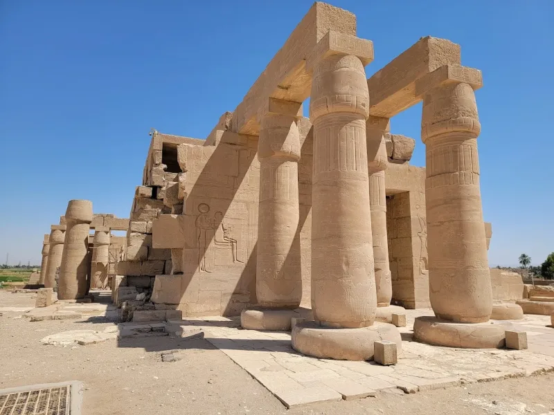 The Ramesseum mortuary temple of Ramesses II with massive fallen statues and painted reliefs on Luxor's West Bank