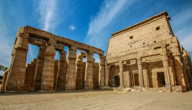 Photographer capturing ancient monument details at a Luxor temple with professional camera equipment