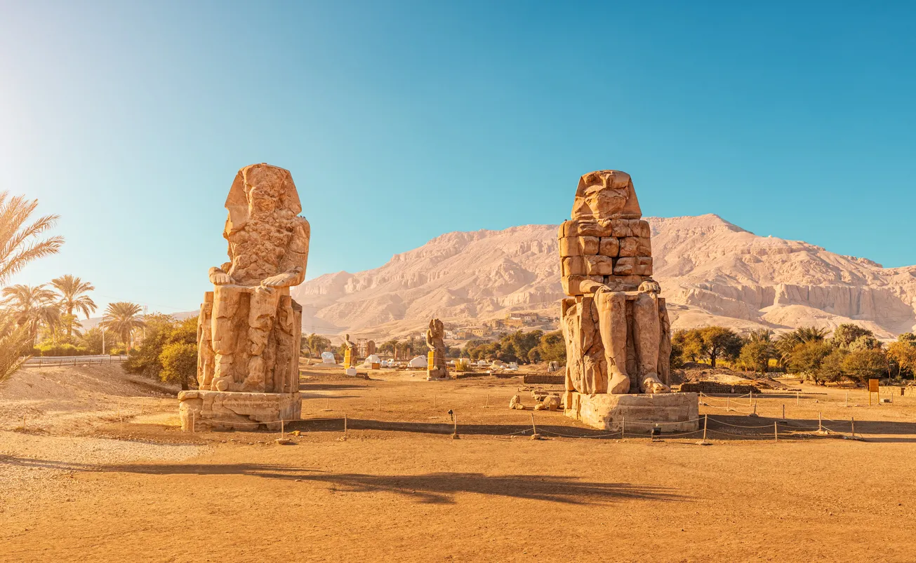Colosii lui Memnon, statui gemene ale lui Amenhotep III la răsărit cu turiști în apropiere