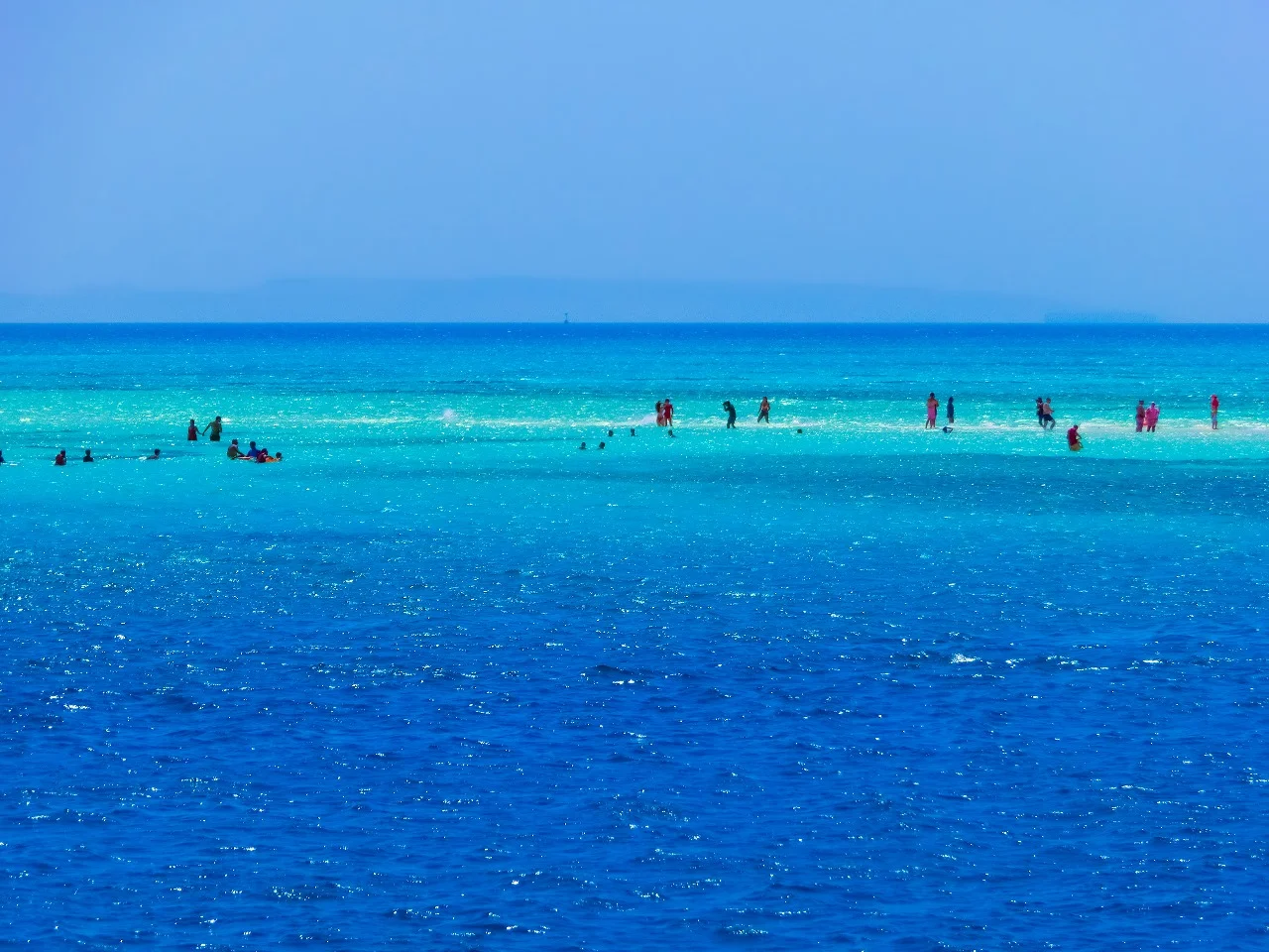 A panoramic view of White Island in Sharm El Sheikh, Egypt, displaying a picturesque blend of rugged coastal beauty, white sandy shores, and sparkling sea