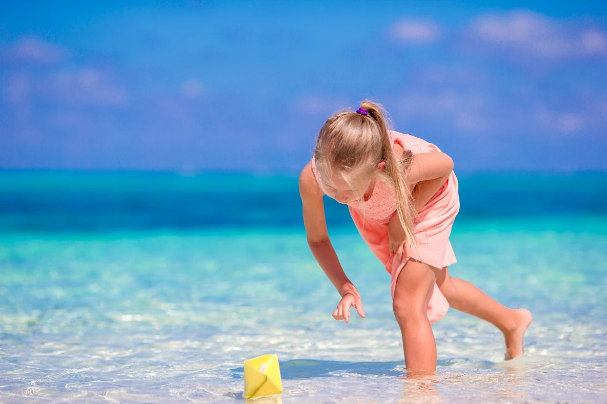Adorable little girl playing on the white sands of White Island Sharm El Sheikh, with turquoise waters in the background creating a perfect family-friendly beach day during a Ras Mohammed excursion